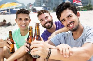 Three guys drinking beer at beach